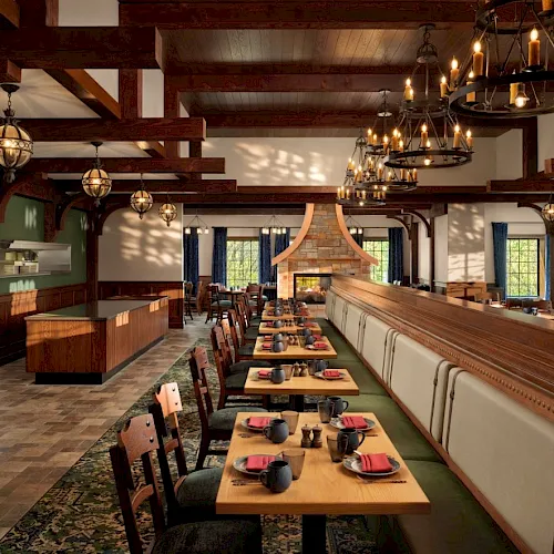 A warm rustic dining hall with long wooden tables, cushioned chairs, a central fireplace, and glowing chandeliers overhead.